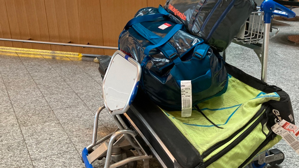 Packed luggage sits on an airport cart