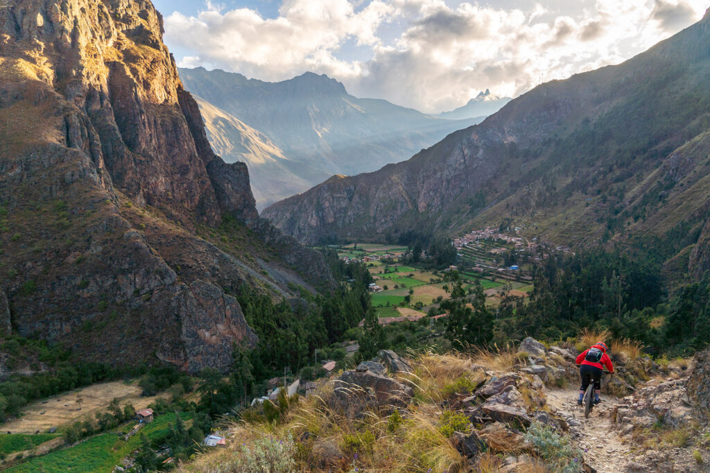A mountain biker in a red jacket riding in Peru