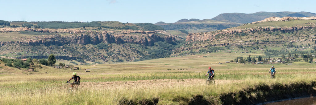 Mountain bikers riding by a river in Lesotho