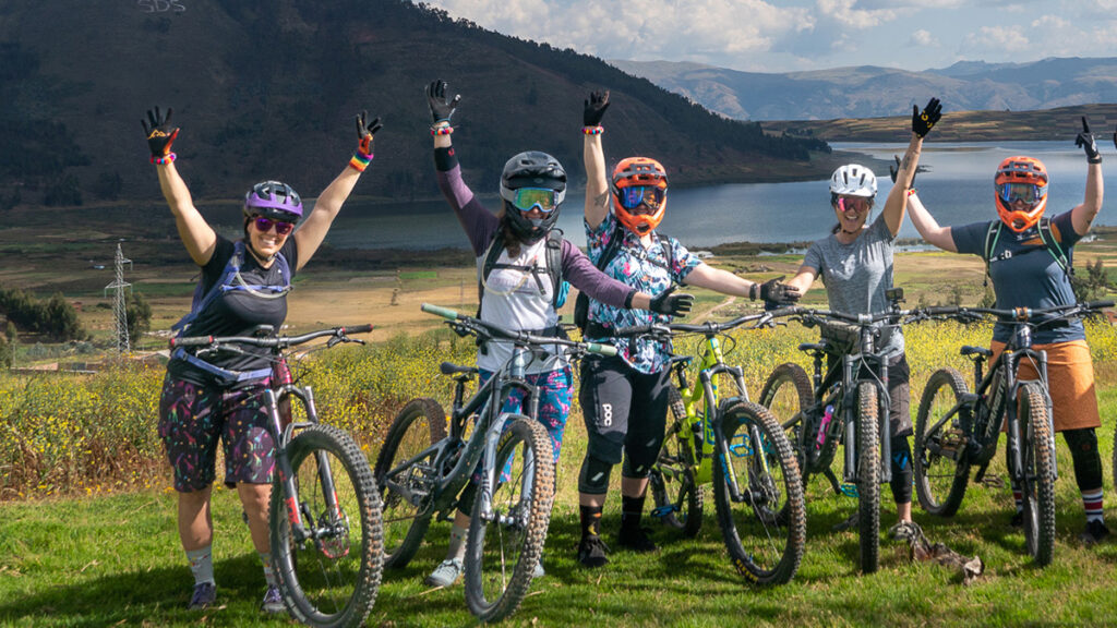 A group of mountain bikers with arms outstretched in Peru