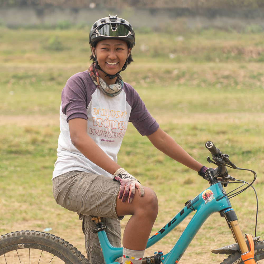 Nishma sits on her bike wearing a World Ride tshirt