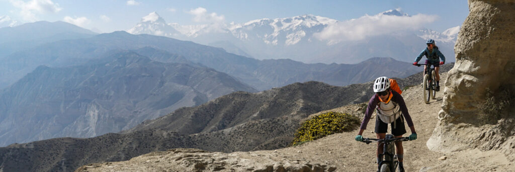 Riders on Upper Mustang with snowy mountains in the background
